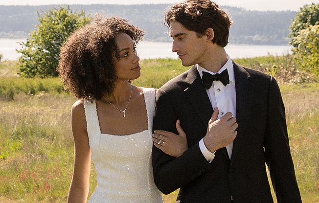 A bride and groom stand together in a field