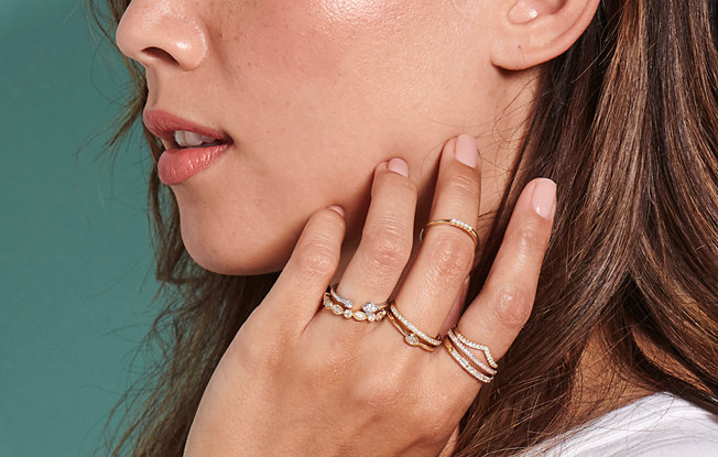 Woman displaying stacked rings of different styles on 3 of her fingers