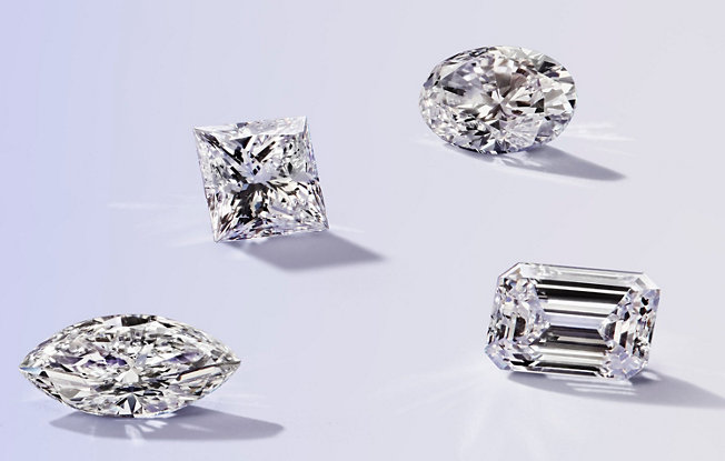 four fancy shaped loose diamonds on a purple background