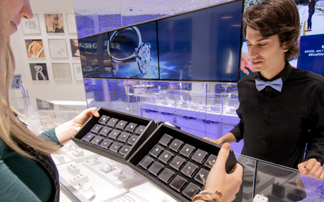Diamond expert, Nathan, showing diamonds to a customer in a jewelry store.