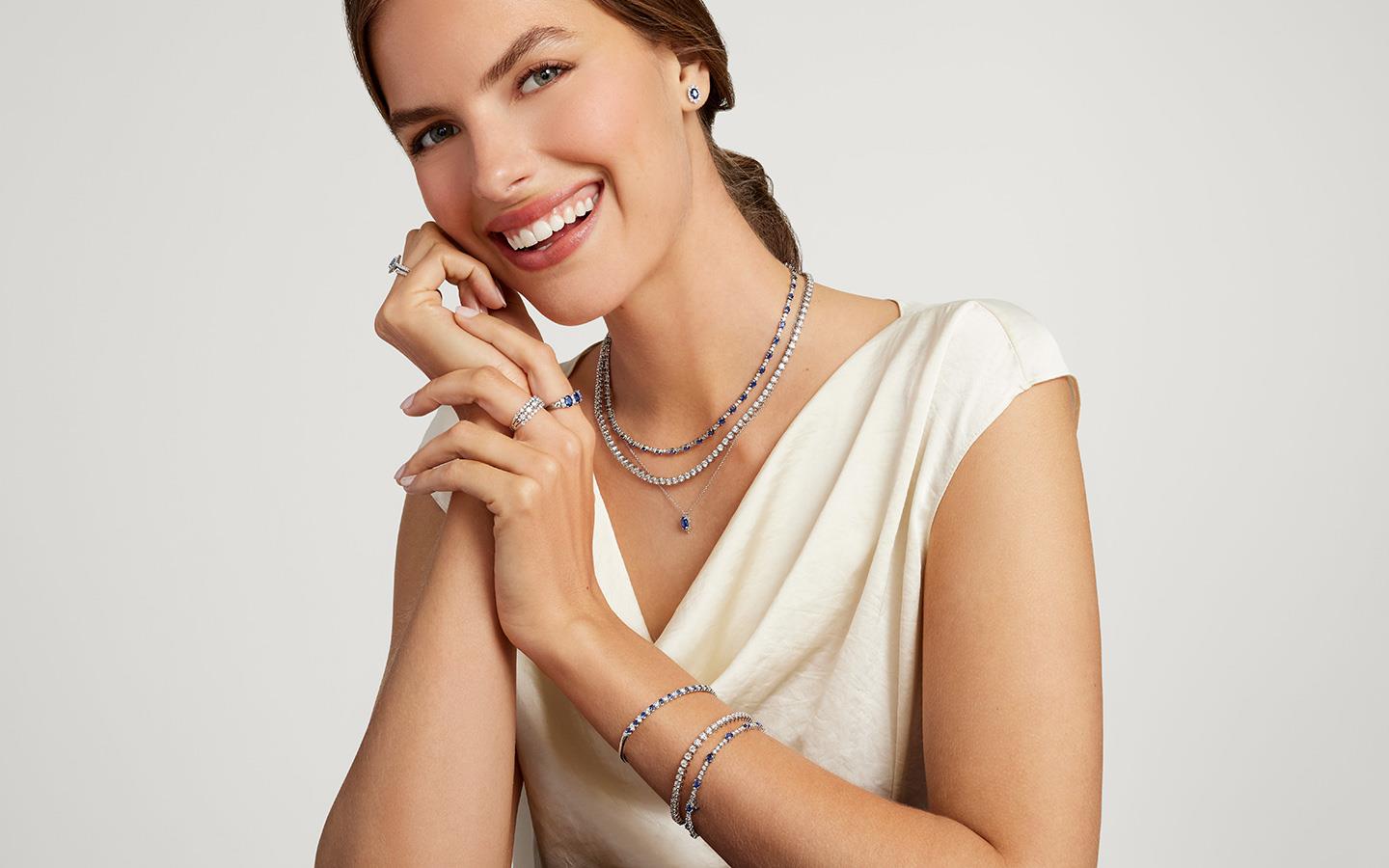 Woman smiling in layered necklaces.