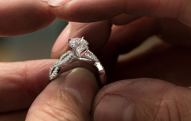 Close up of a jeweler setting a diamond in an engagement ring
