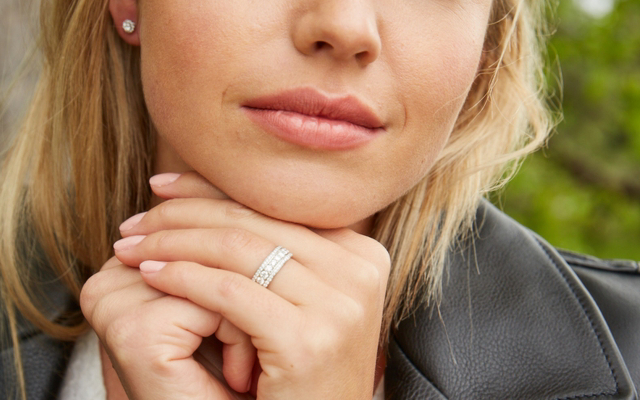 Close up of a woman posing, her wedding band is the focus
