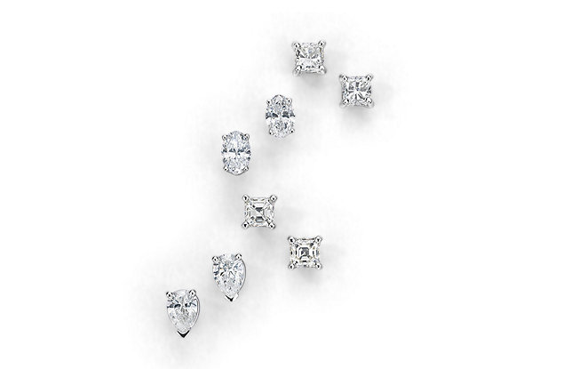 Four pairs of diamond stud earrings on a white background