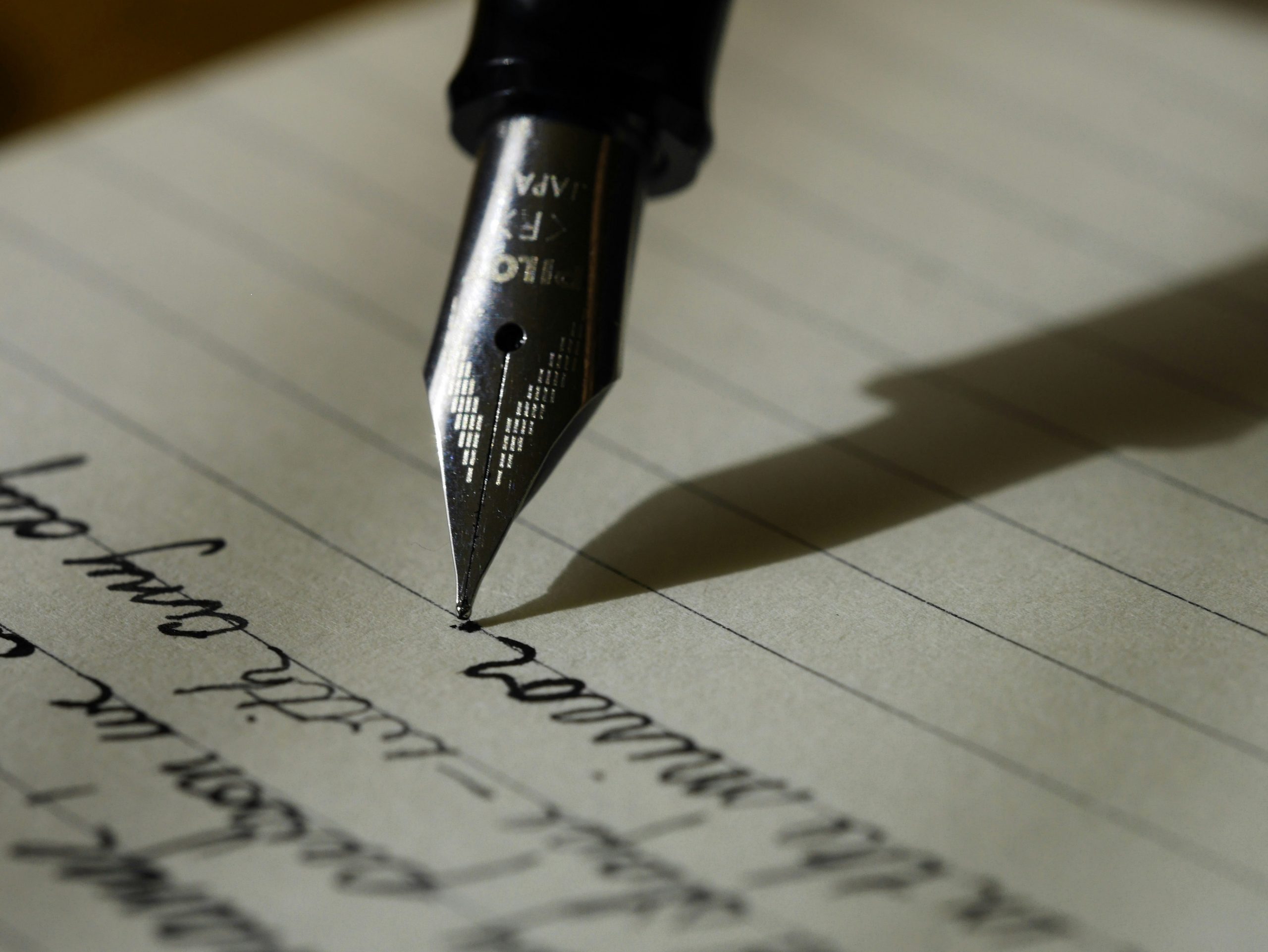 Close up of fountain pen writing a letter.