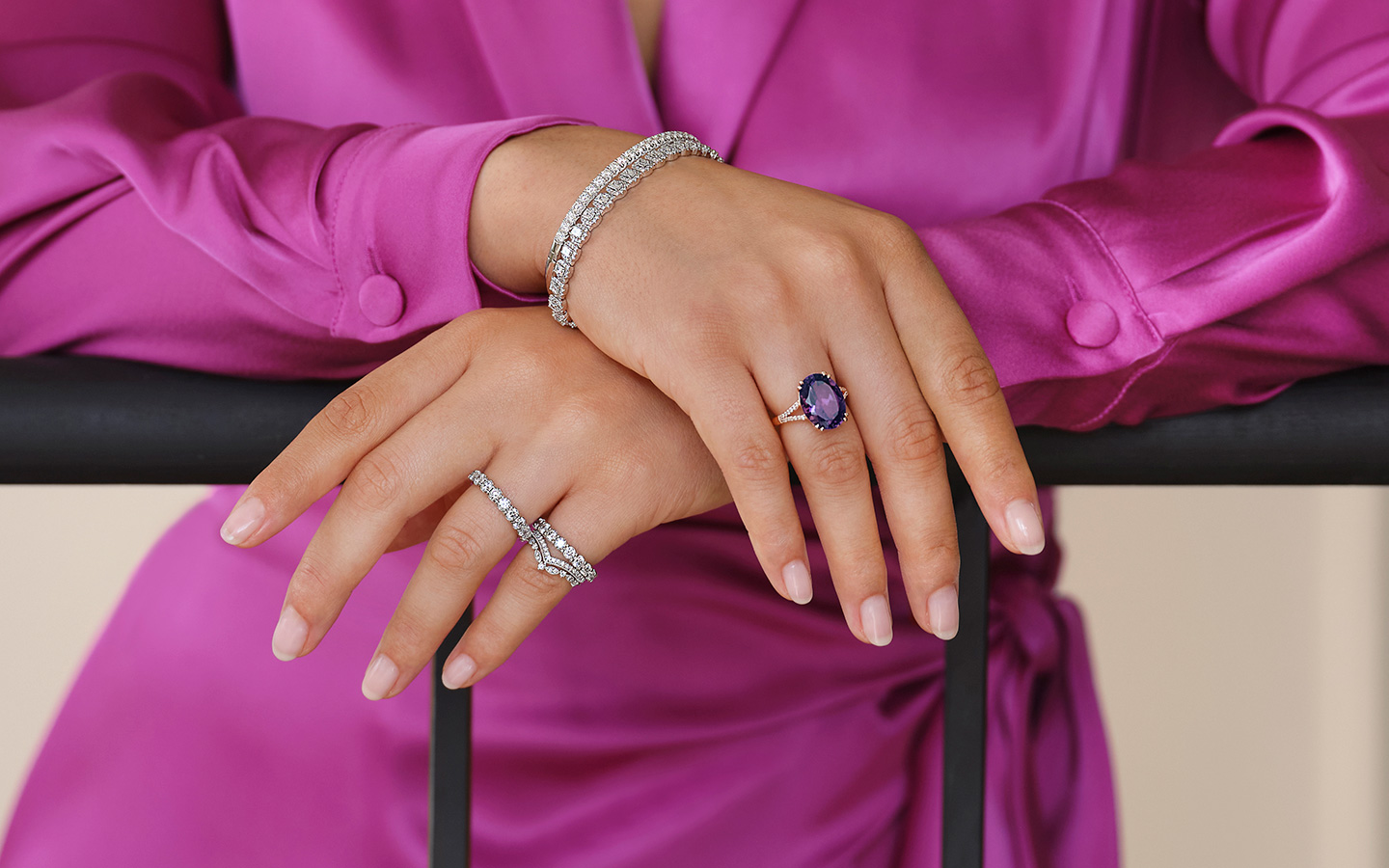 Photo of a woman's hands, she is wearing a gemstone cocktail ring.