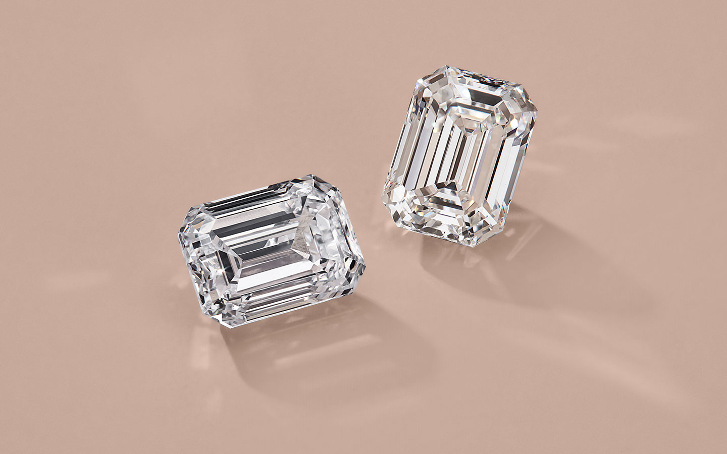 Loose emerald diamonds on a light background.