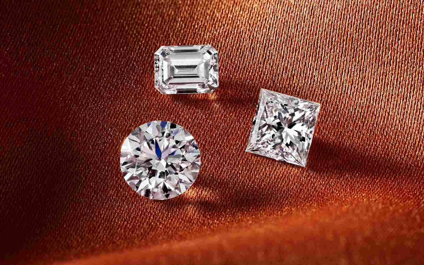 Three loose diamonds with round, emerald and princess cut diamonds.  