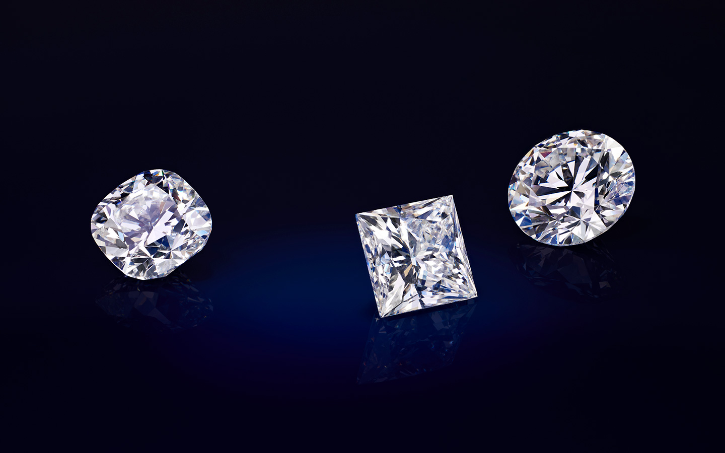 Three loose diamonds in round, cushion and princess shapes.