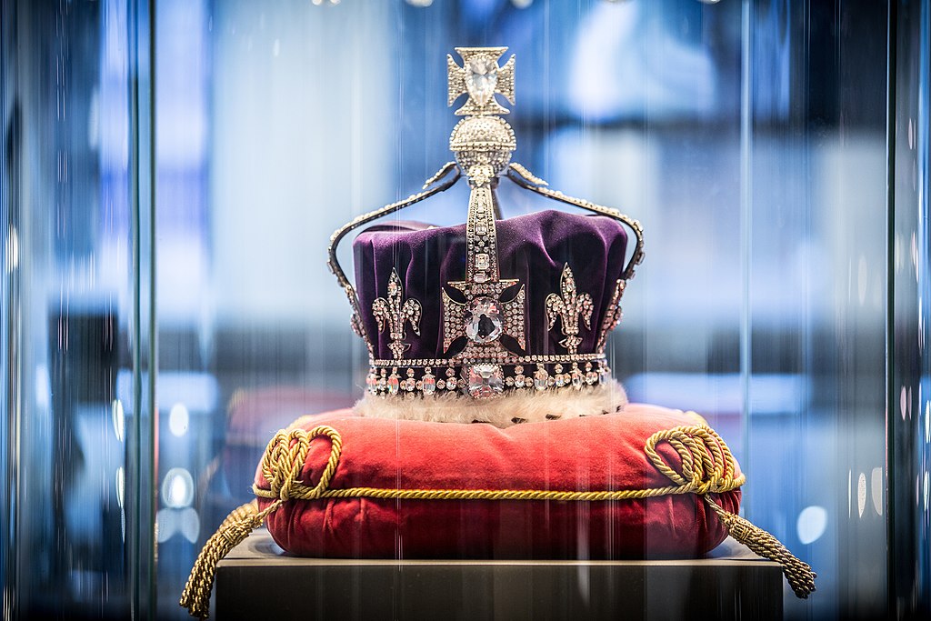 British royal crown with diamonds and platinum set atop a pillow. 
