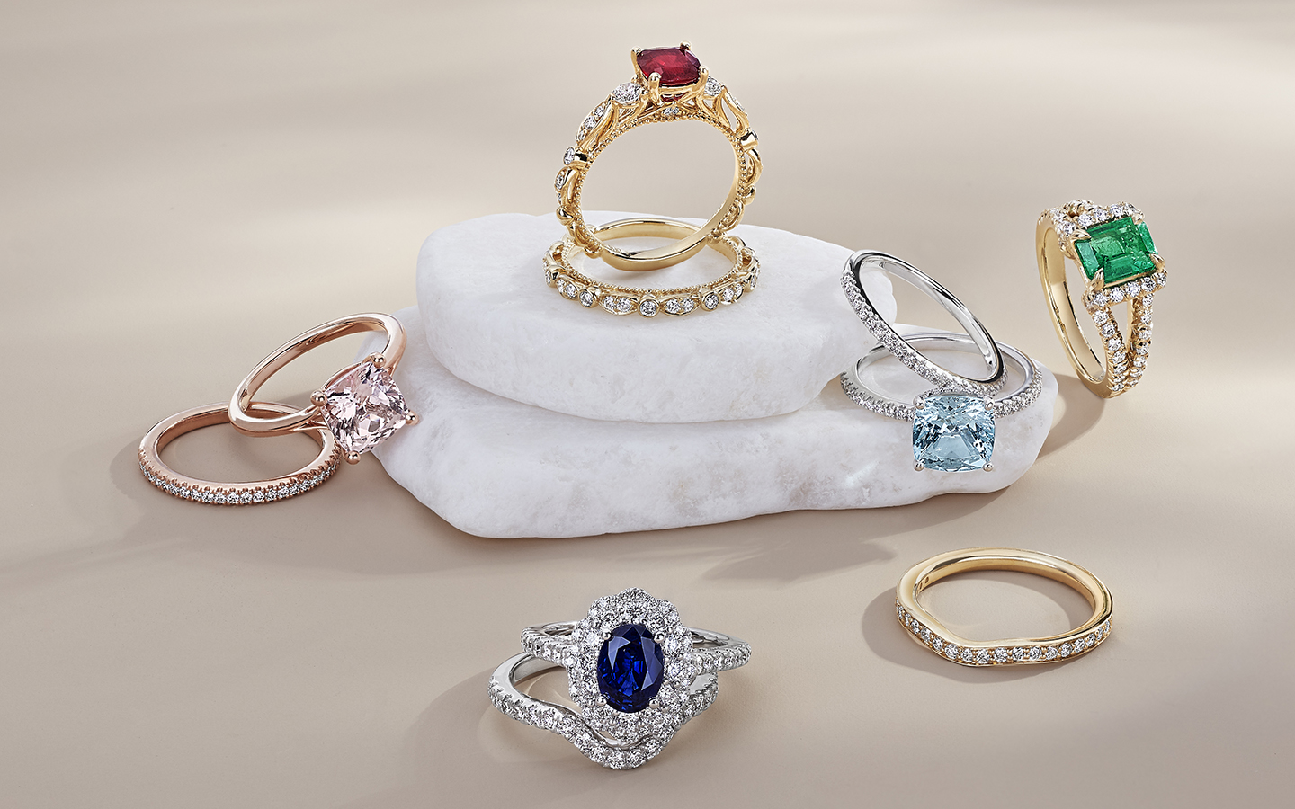 Gemstone engagement rings on a light background.