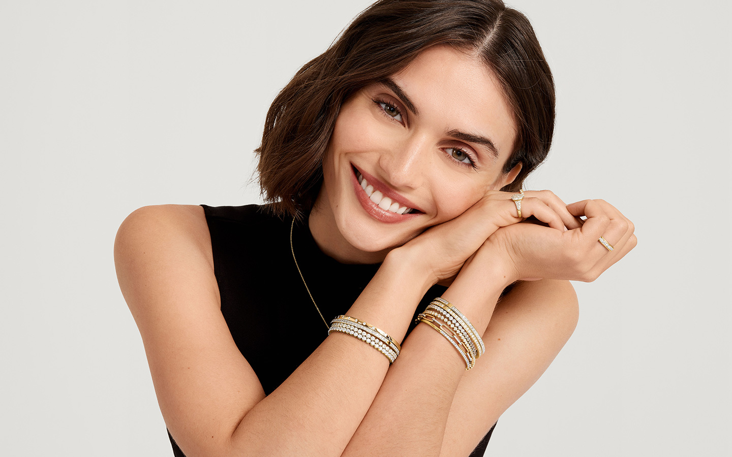 Smiling woman wearing tennis bracelets.