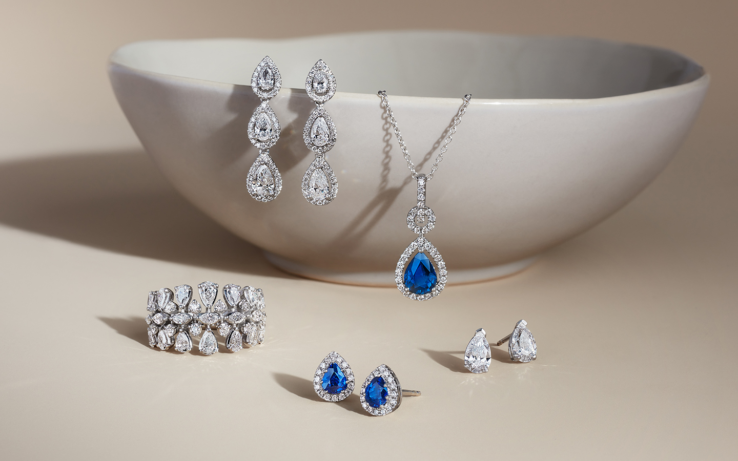 Diamond and sapphire jewelry outside of a storage dish.