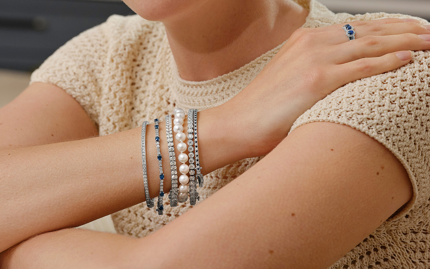 Close up of a woman’s wrist, she is wearing multiple bracelets. 