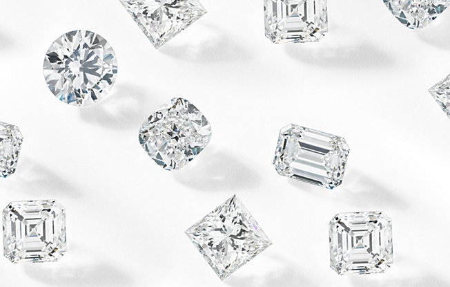 several loose diamonds of various cuts spread across a white background