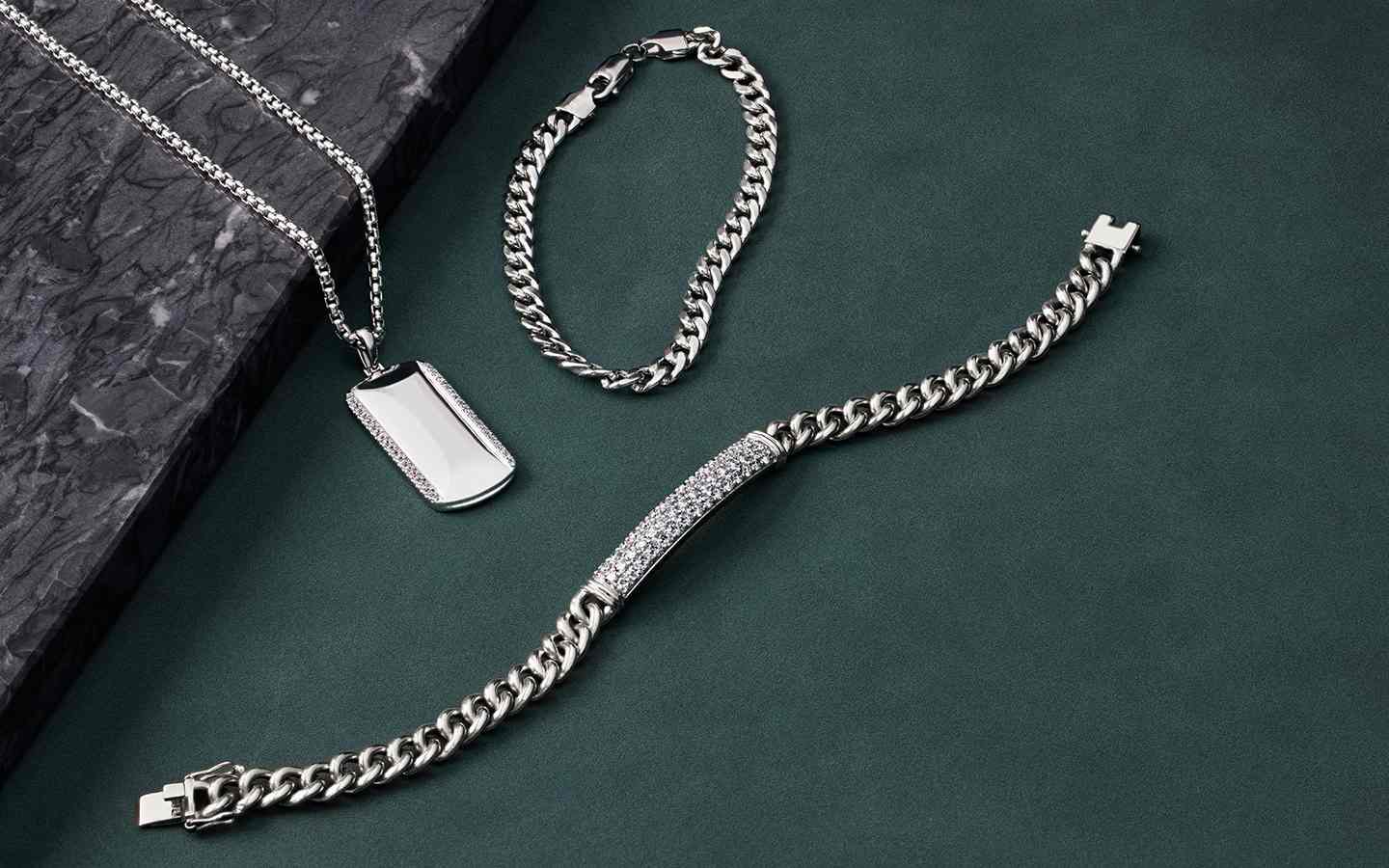 Men’s jewelry with two bracelets and a dog tag necklace.