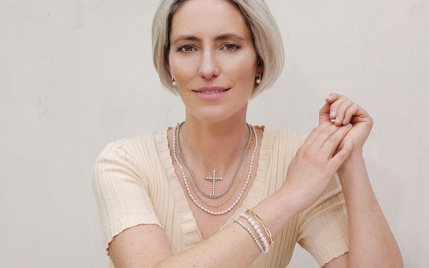 Woman wearing multiple Blue Nile jewelry pieces in mixed metal styles.