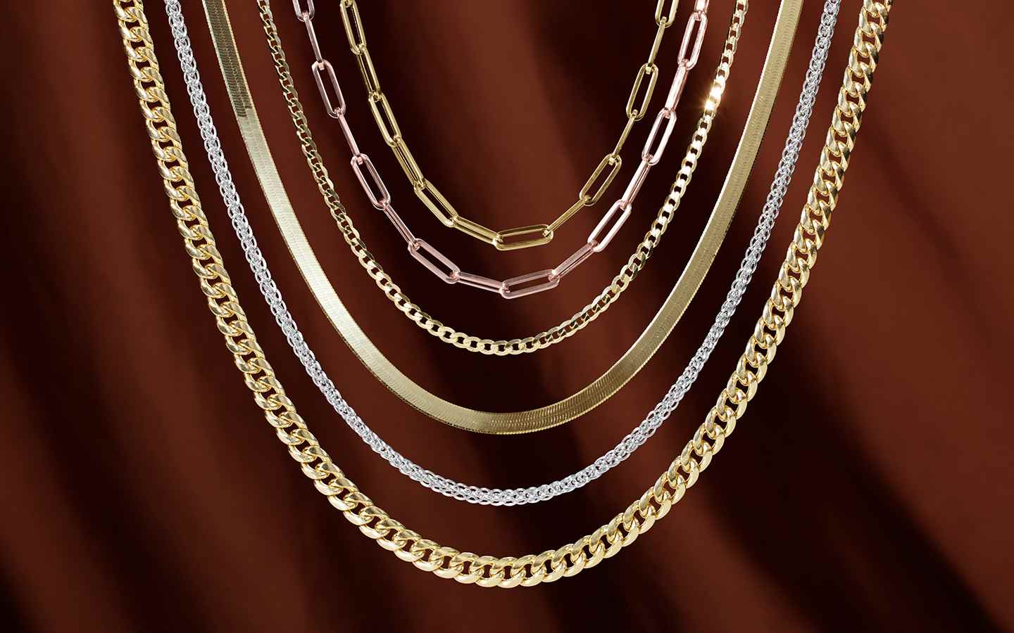 Chain necklaces including Cuban, herringbone and paperclip chains in gold.