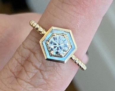 Godfrey’s ‘Motu’ ring with inlaid mother-of-pearl and beaded gold detail forming a luminous halo around the center diamond.