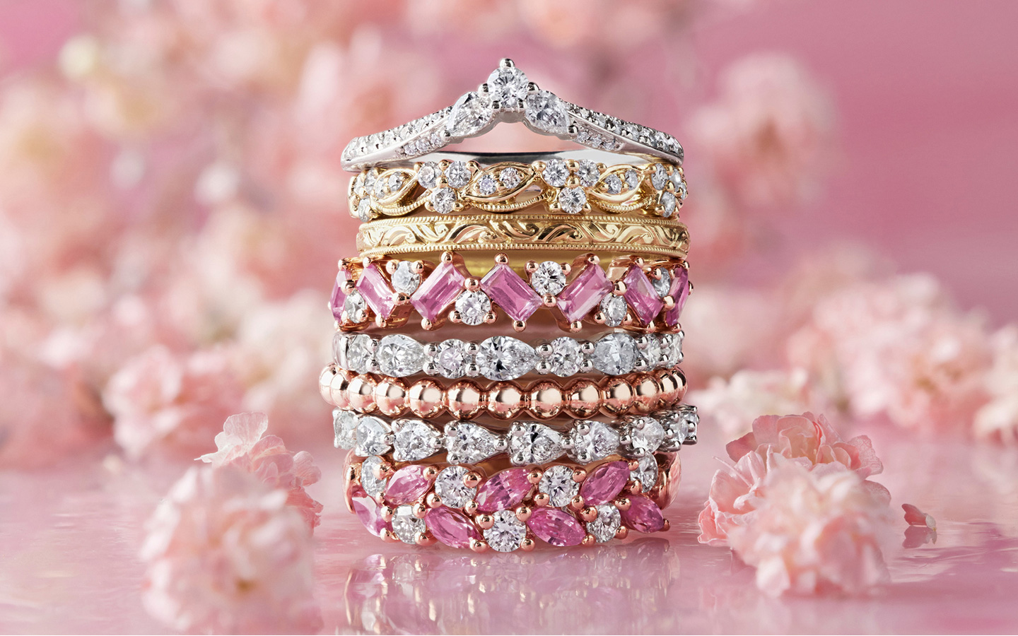 Stack of gold and gemstone rings, including ring spacer bands.