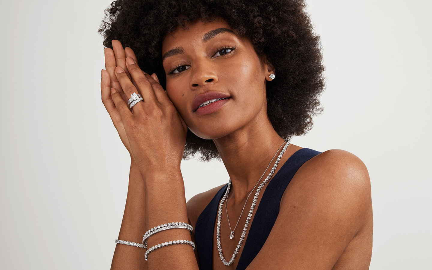 Woman wearing diamond jewelry including soldered rings.