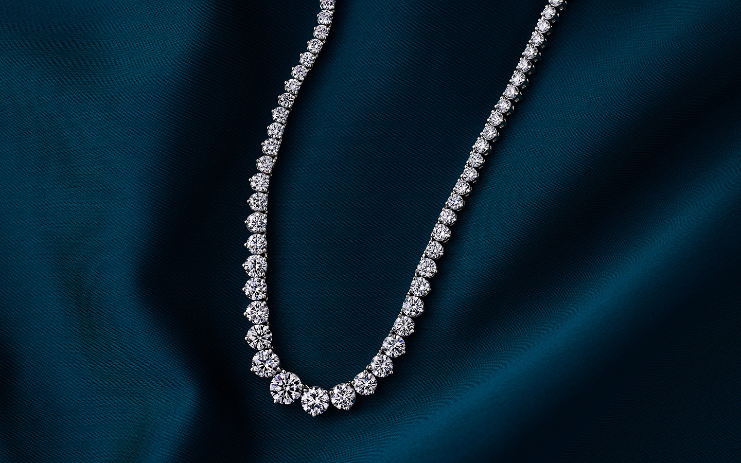 Diamond tennis necklace with diamonds of graduating sizes. 
