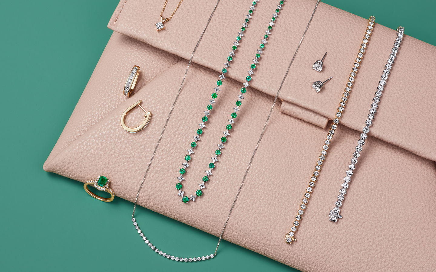 Diamond and emerald jewelry displayed on a travel pouch.