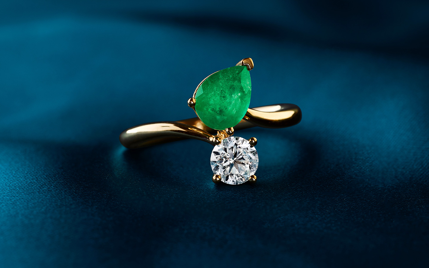 Two-stone unique engagement ring with an emerald and diamond.