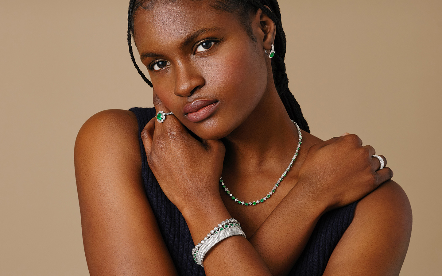 Photo of a woman wearing diamond and emerald jewelry. 