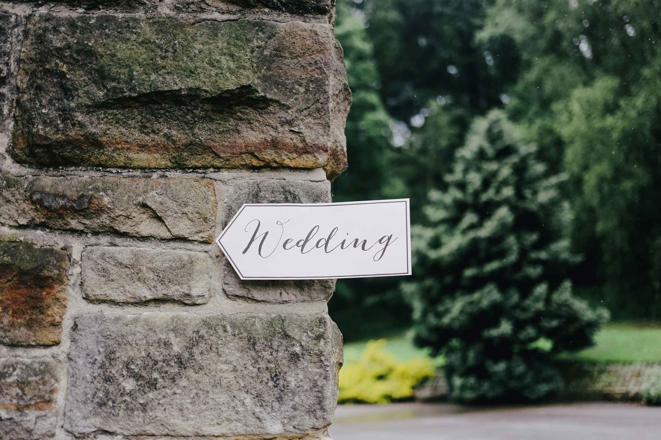 Paper sign pointing to a wedding reception.