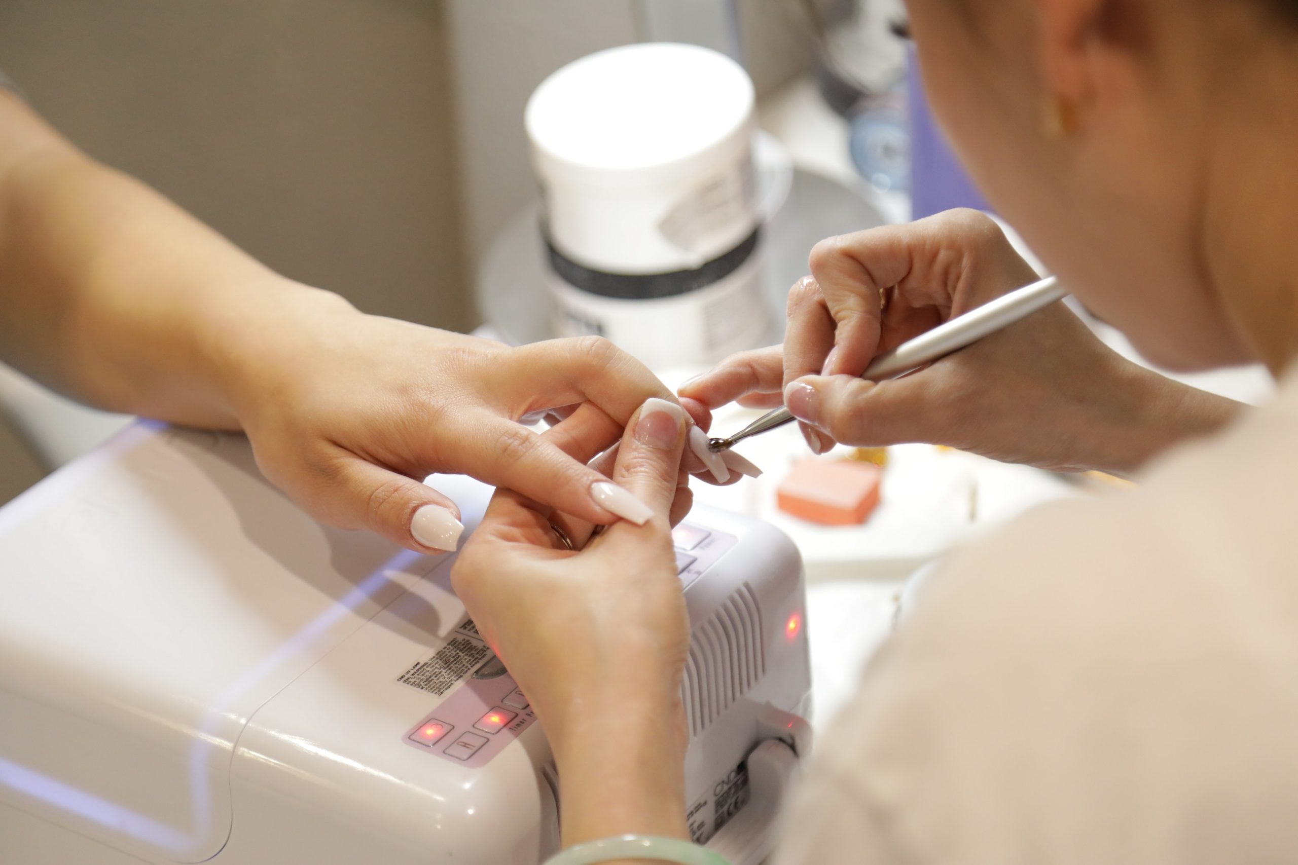 Person having their nails painted in a salon.
