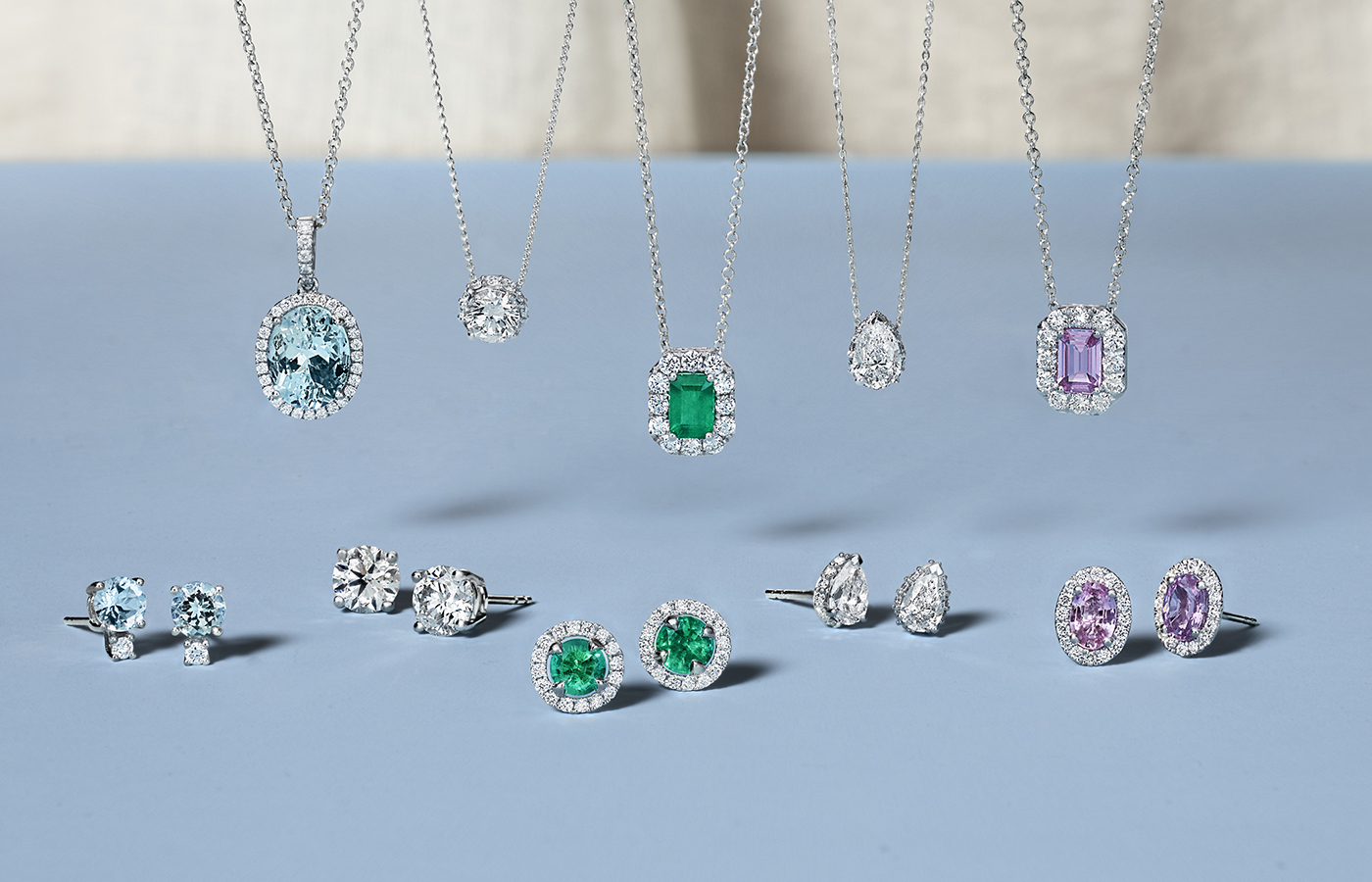 White gold necklaces and earrings, with emeralds and sapphires.