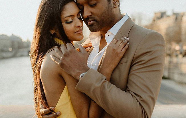 A woman in a yellow dress embraces a man in a suit