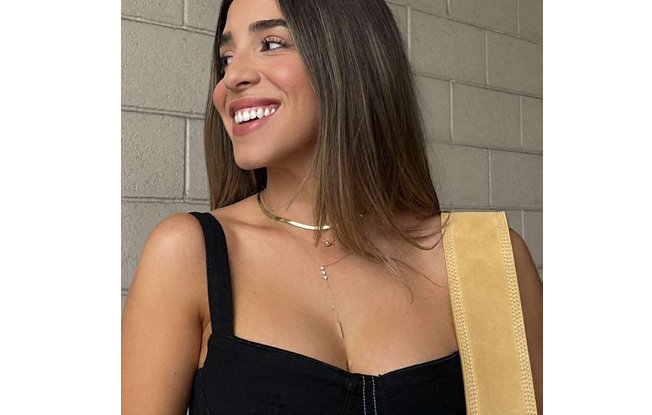 Smiling woman wearing gold necklace and diamond pendants