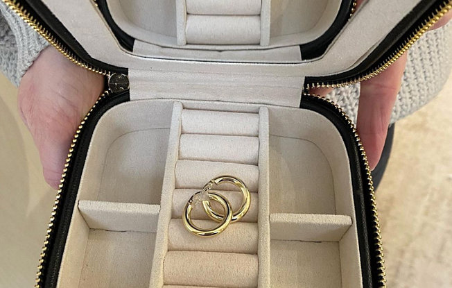 Photo of gold hoop earrings in a small travel jewelry case