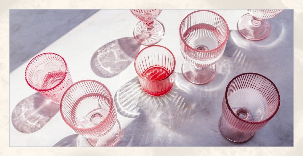 Matching pink drinkware on a marble table. 