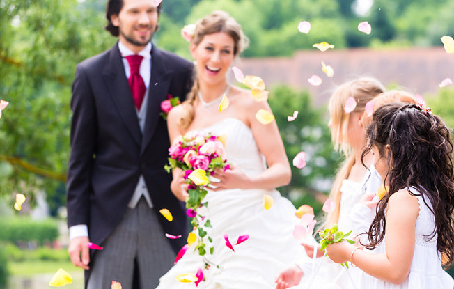 A bride and groom stand with their flower girls at a wedding ceremony