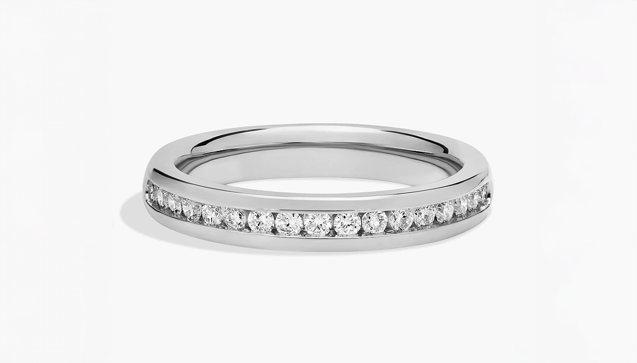 Channel set diamond ring in platinum featuring a clean, modern band with secure H color diamond detailing