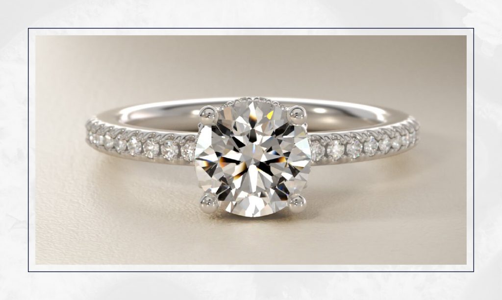 Round diamond solitaire with a hidden halo beneath the center stone, a subtle detail widely seen in trendy engagement rings
