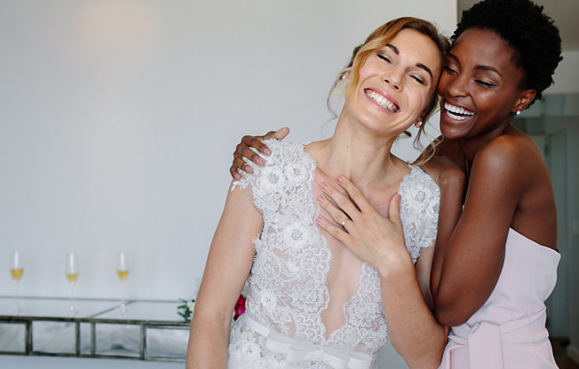 A bride and bridesmaid hugging