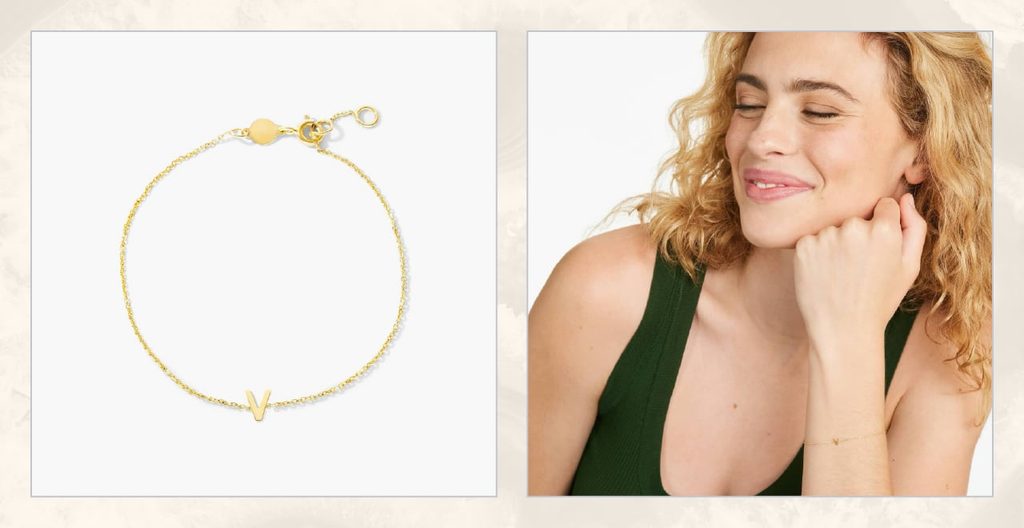 Woman wears gold V initial bracelet.