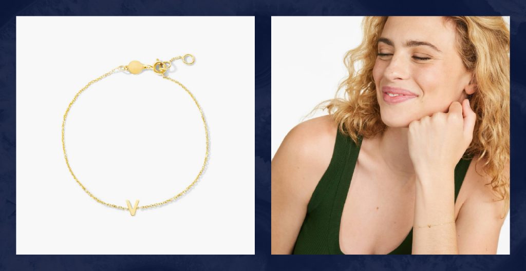 Woman wears gold V initial bracelet.