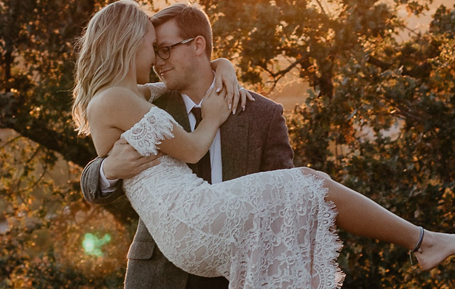 A groom holding his bride in his arms