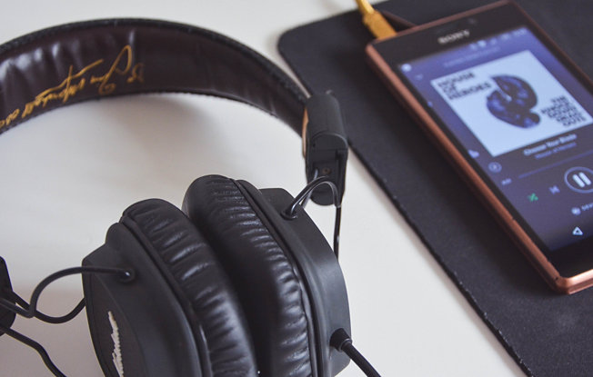 A headset and an Iphone sit on a white table