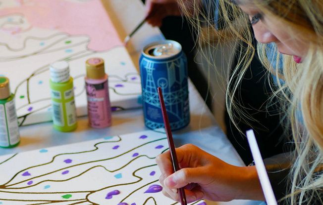 A woman sitting at a table painting