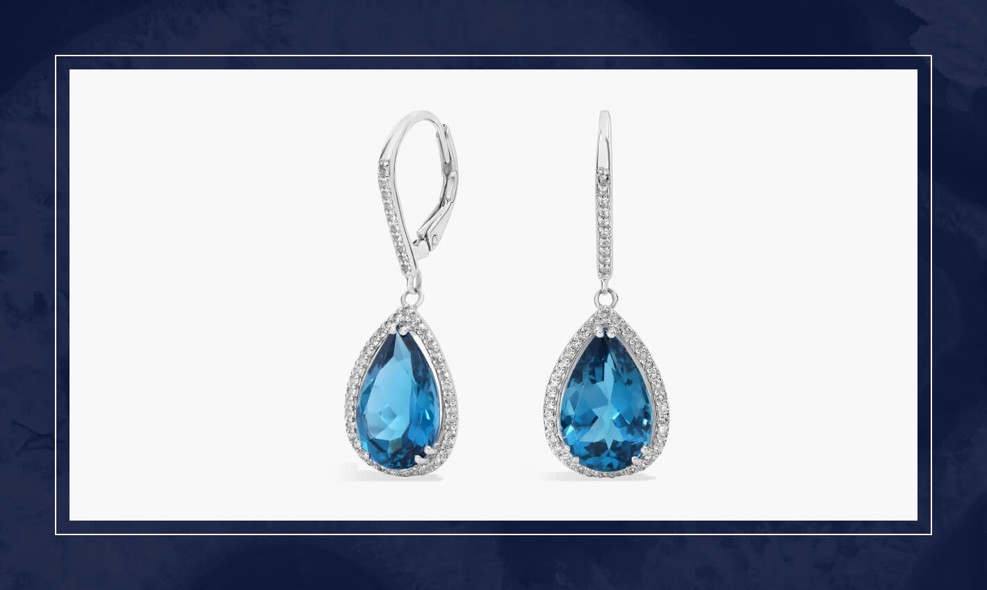 Blue gemstone drop earrings framed by diamond halos in white gold, designed with movement and a refined teardrop shape.