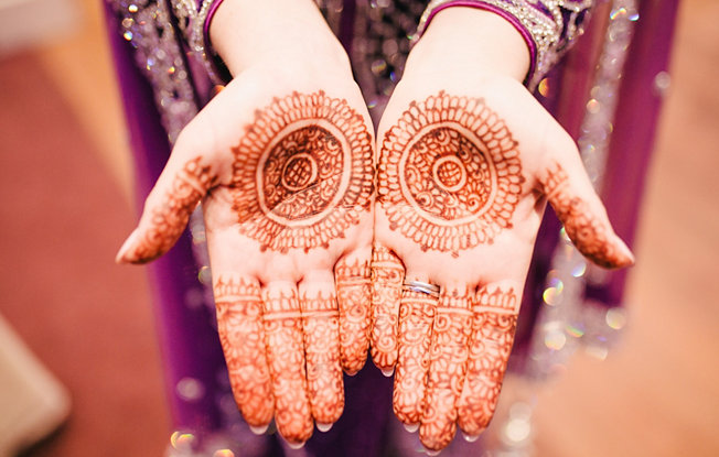 An indian bride displays the wedding henna on the palms of her hands
