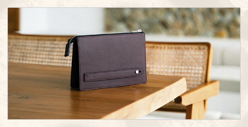 A dark purple bag rests on a wooden table. 